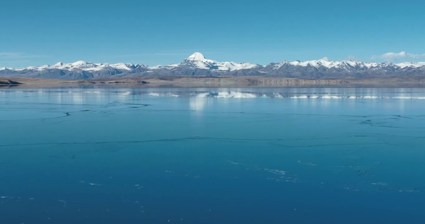 航拍湖水与冰面远处的山峰与地形视频素材