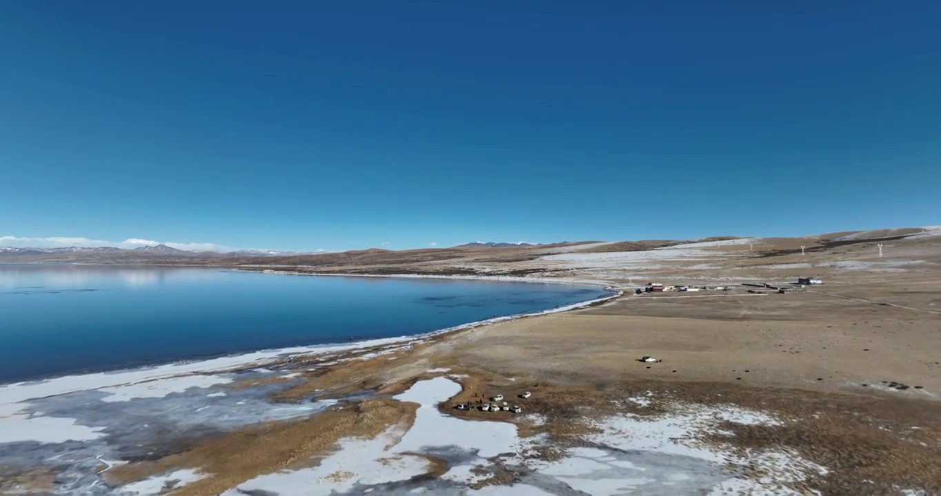 航拍湖水与冰面远处的山峰与地形视频素材