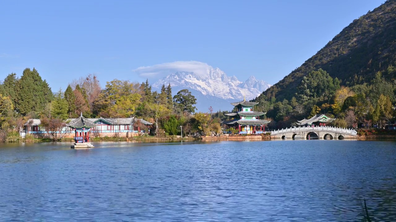 云南省丽江市黑龙潭公园和玉龙雪山冬季白昼晴天实时视频素材