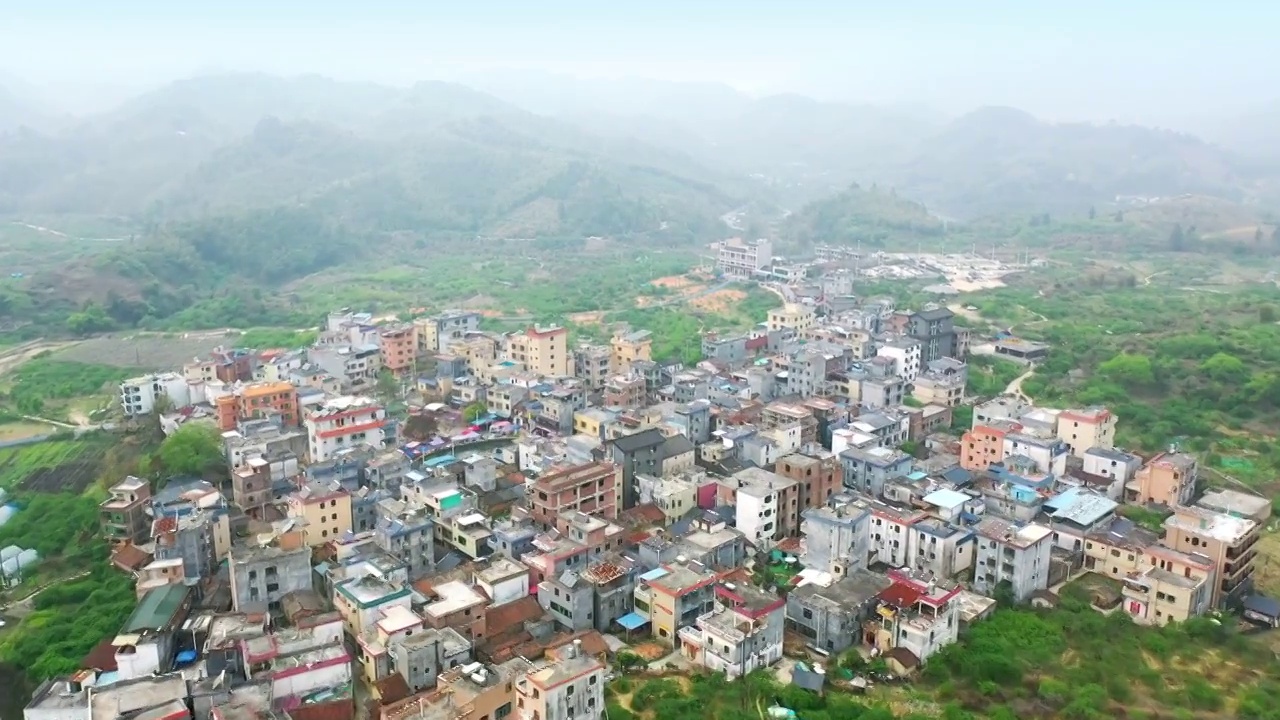 航拍春天大山森林环绕新农村面貌农民自建房浓雾散开植被覆盖原生态林区绿化山林乡村振兴乡镇建设开发旅游视频素材