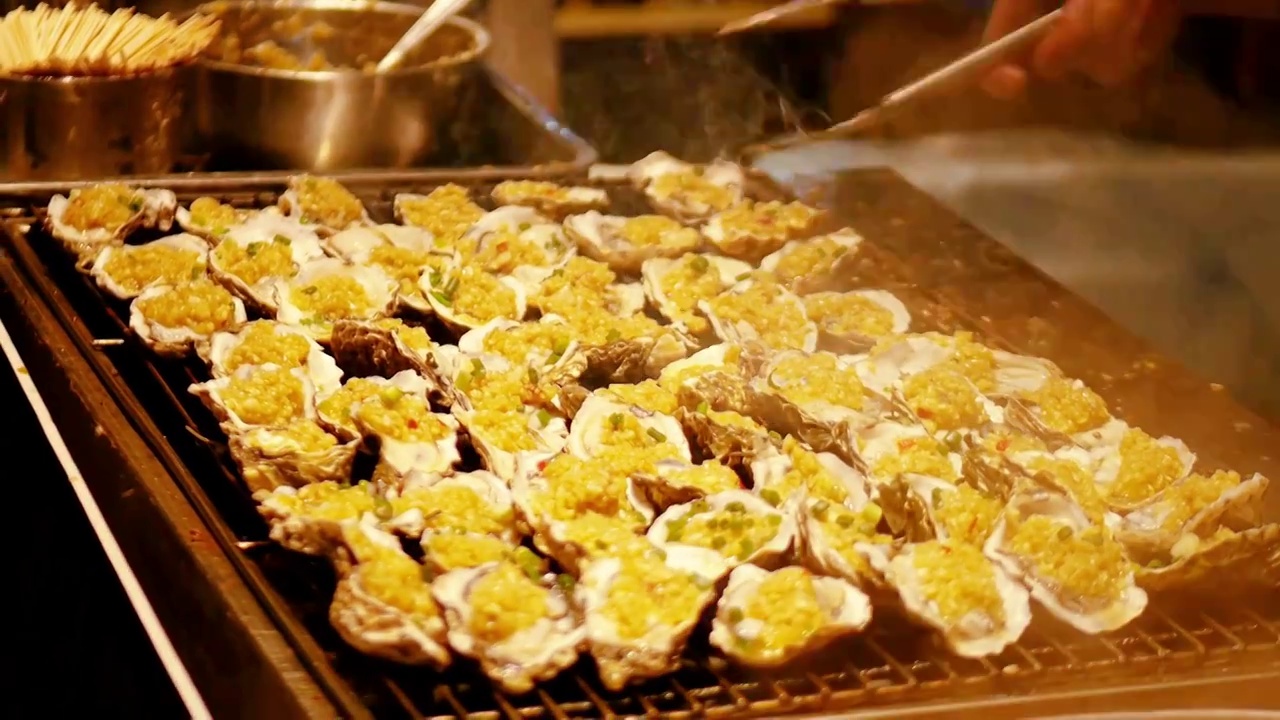 夜市小吃摊新鲜蒜蓉小米辣椒香油烤湛江时令生蚝南方城市美食节湛江海口沿海地区民间小吃小商贩自主创业烧烤视频素材