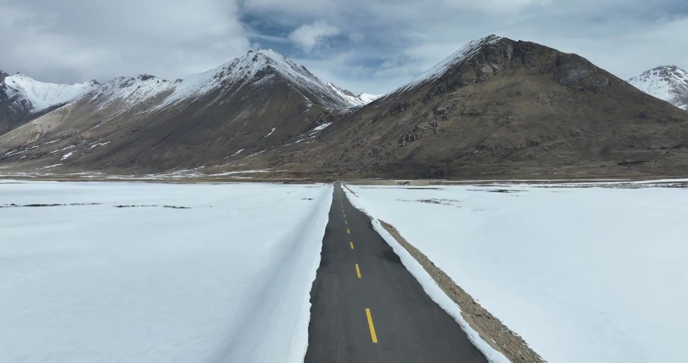 航拍青藏高原高海拔雪原中积雪的道路视频素材