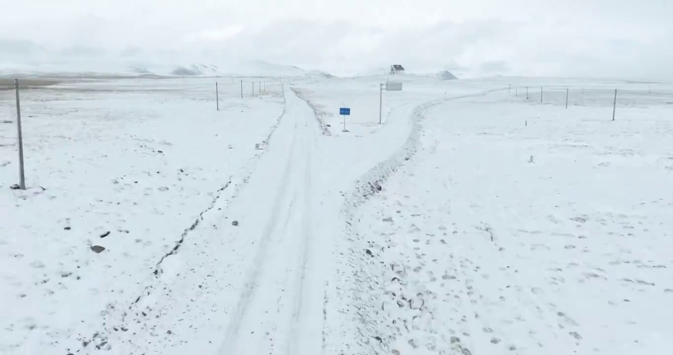 航拍青藏高原高海拔雪原中积雪的道路视频素材