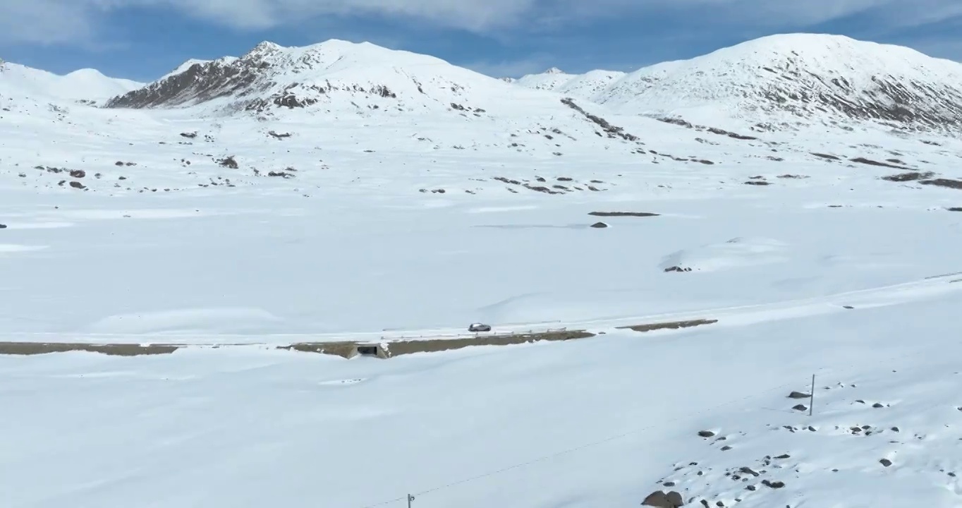 越野车SUV行驶在青藏高原高海拔雪原中积雪的道路上视频素材