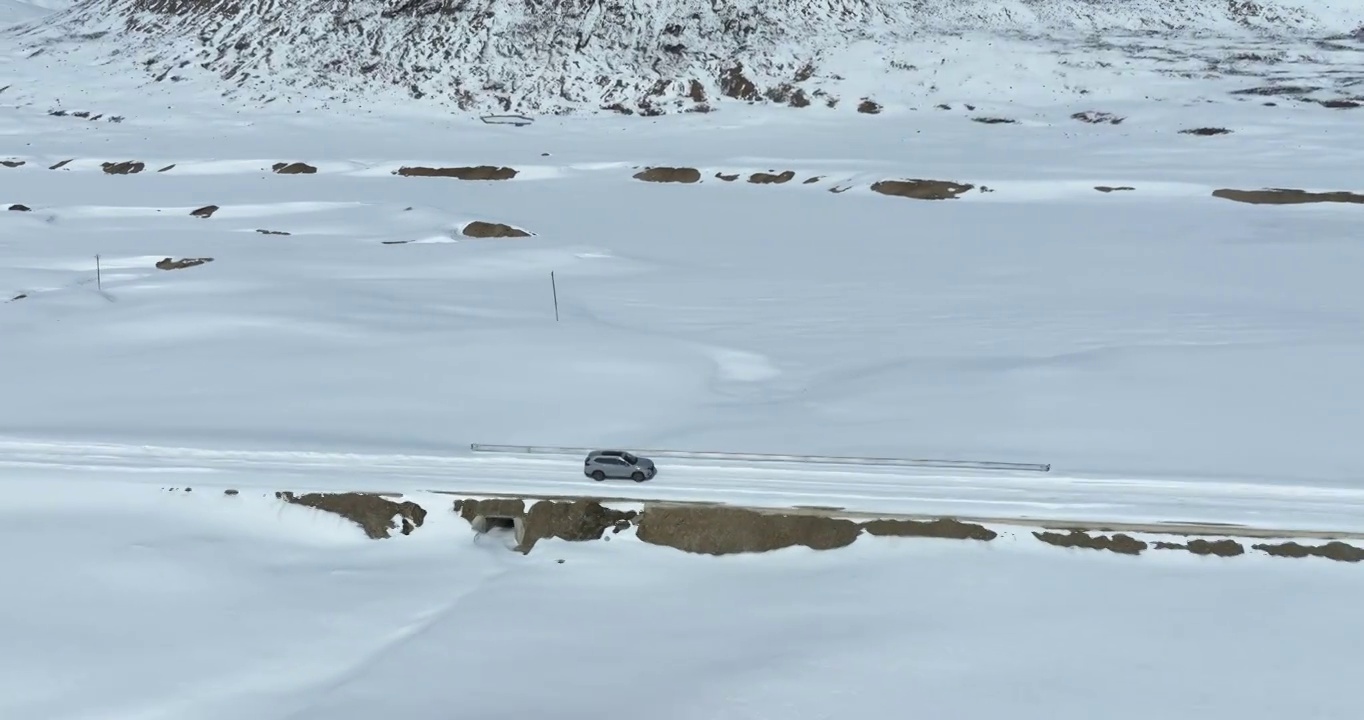 越野车SUV行驶在青藏高原高海拔雪原中积雪的道路上视频素材