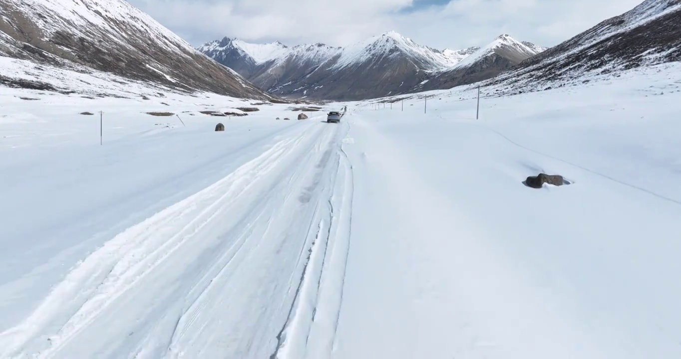 越野车SUV行驶在青藏高原高海拔雪原中积雪的道路上视频素材