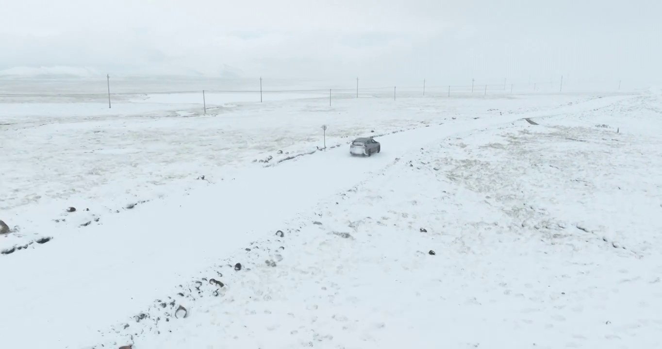 越野车SUV行驶在青藏高原高海拔雪原中积雪的道路上视频素材