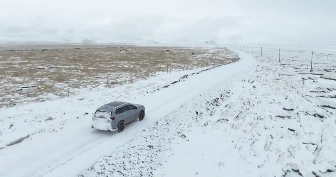 越野车SUV行驶在青藏高原高海拔雪原中积雪的道路上视频素材