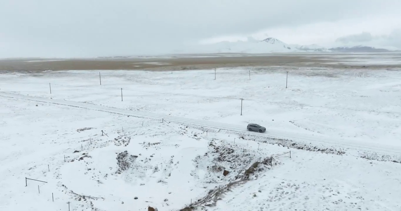 越野车SUV行驶在青藏高原高海拔雪原中积雪的道路上视频素材