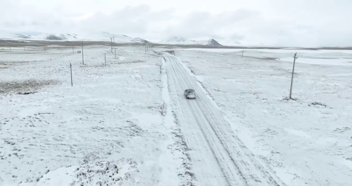 越野车SUV行驶在青藏高原高海拔雪原中积雪的道路上视频素材