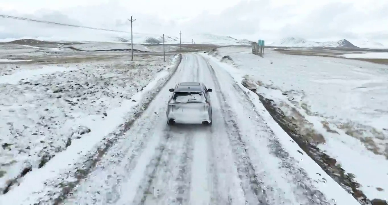 越野车SUV行驶在青藏高原高海拔雪原中积雪的道路上视频素材