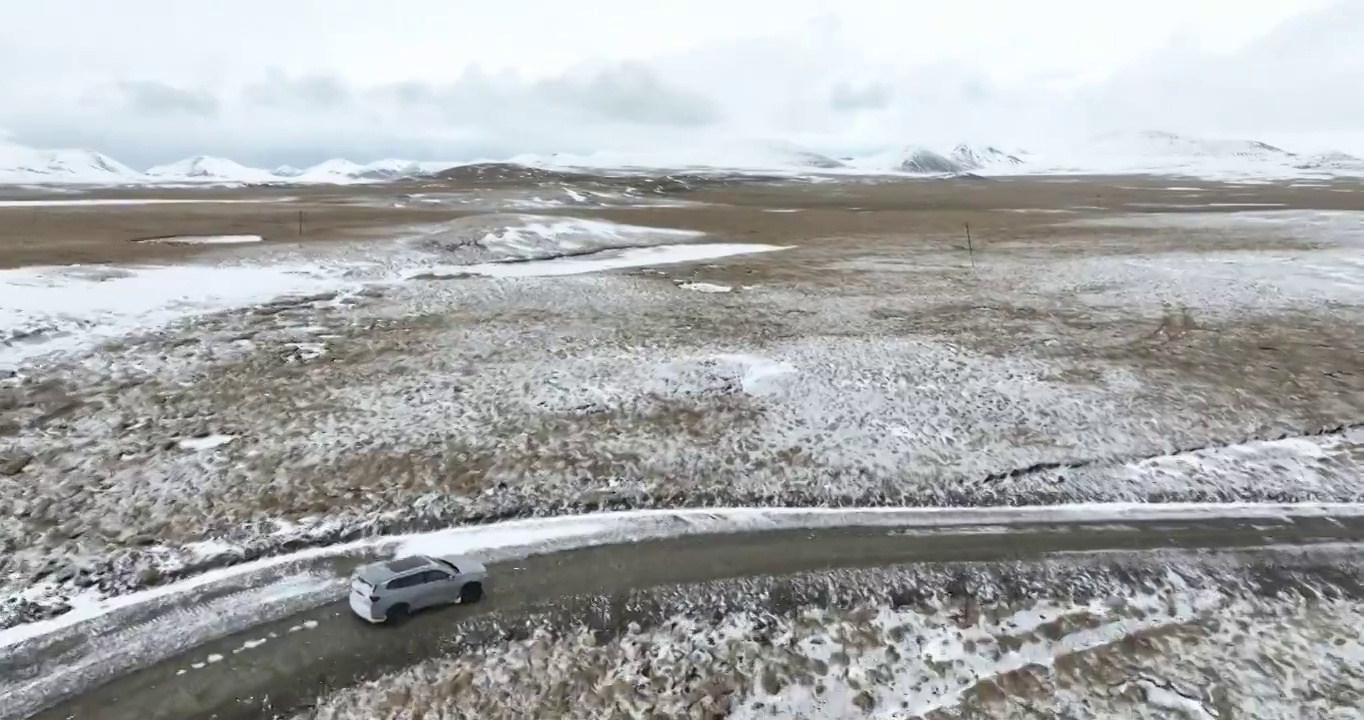 越野车SUV行驶在青藏高原高海拔雪原中积雪的道路上视频素材