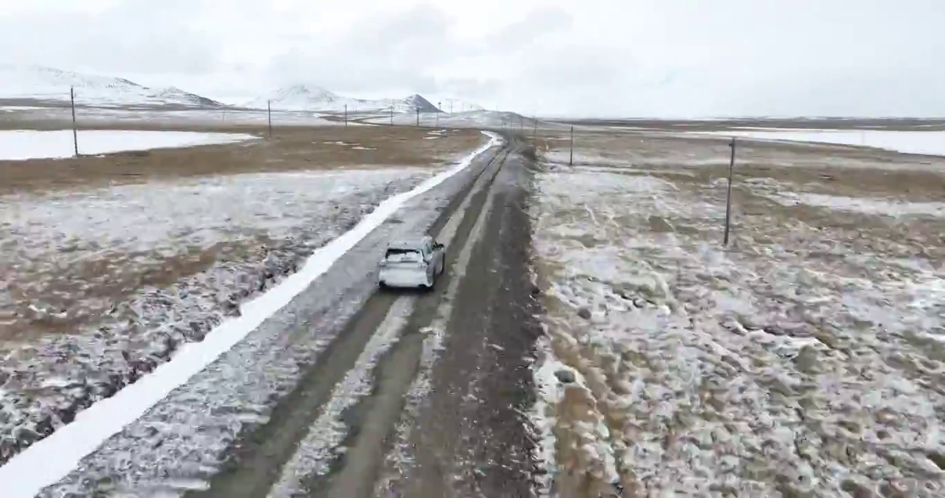 越野车SUV行驶在青藏高原高海拔雪原中积雪的道路上视频素材