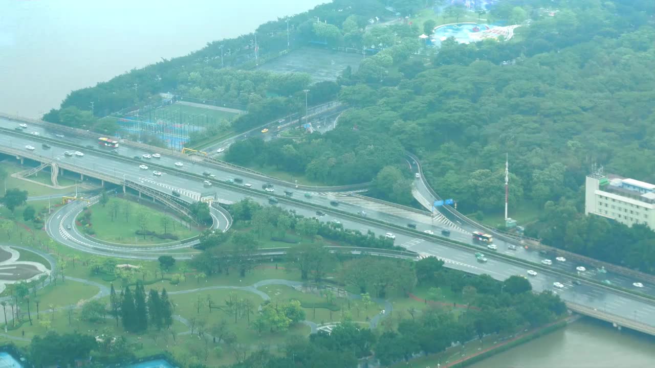 雨季下雨天广州大道通勤交通繁忙高峰期道路湿滑大都市繁华活力无限焕发现代气息绿化公园旁车水马龙车来车往视频素材