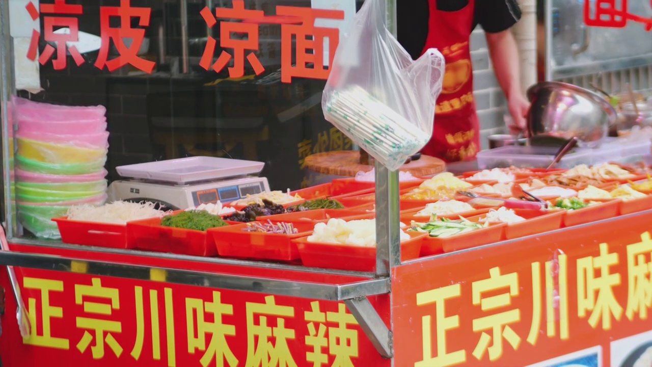 夜市小吃摊川菜麻辣烫凉皮凉面餐饮店食材众多店员正在忙碌准备食物半开放式厨房凉菜凉拌免煮川渝陕西风味菜视频素材