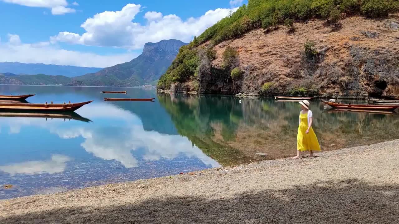 一位女性游客走在泸沽湖岸边视频素材