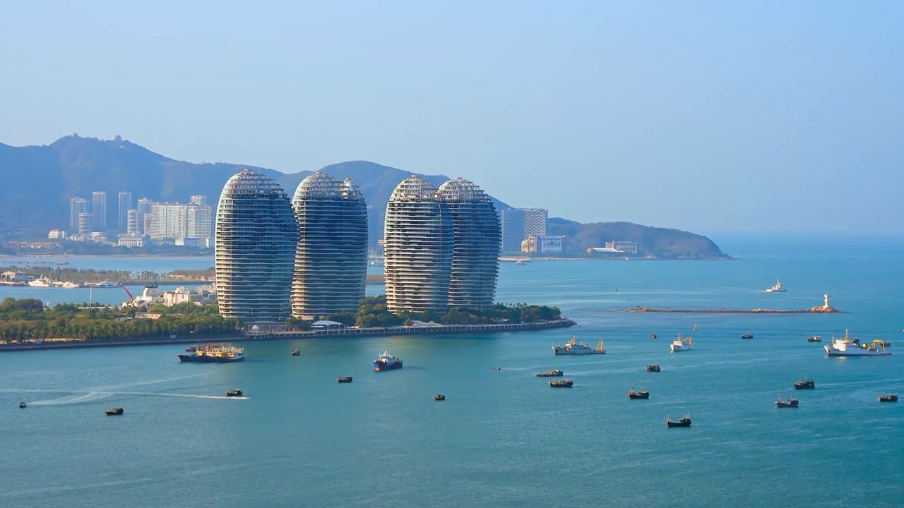 中国海南三亚三亚湾海岸线和凤凰岛城市天际线风光航拍特写视频素材