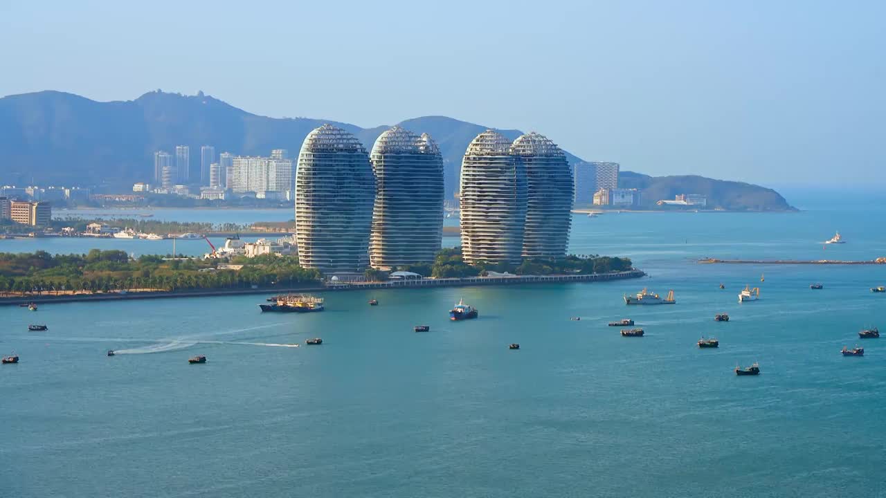 中国海南三亚三亚湾海岸线和凤凰岛城市天际线风光航拍特写视频素材