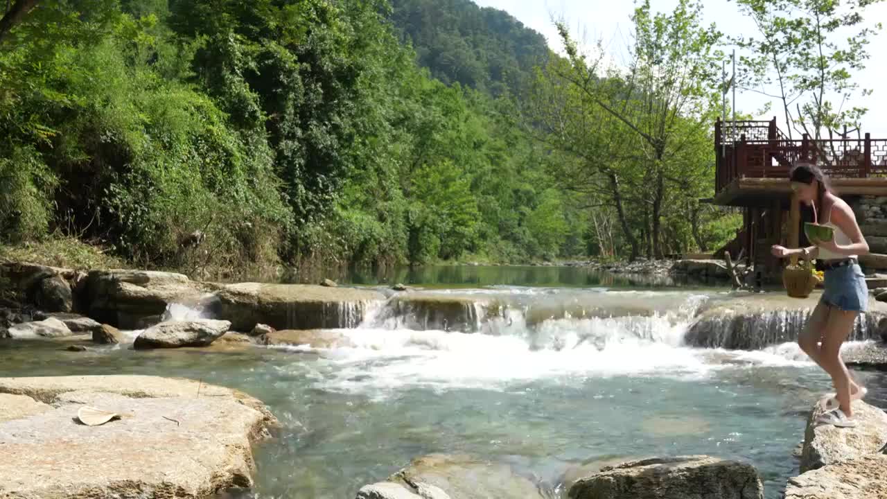 一位美女在湖北宣恩撒野露营小镇河边吃西瓜视频素材