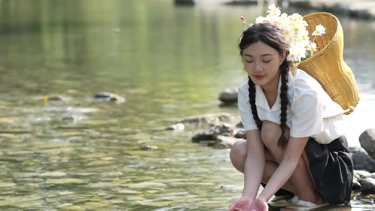 一位美女大学生在湖北宣恩撒野露营小镇河边玩水视频素材