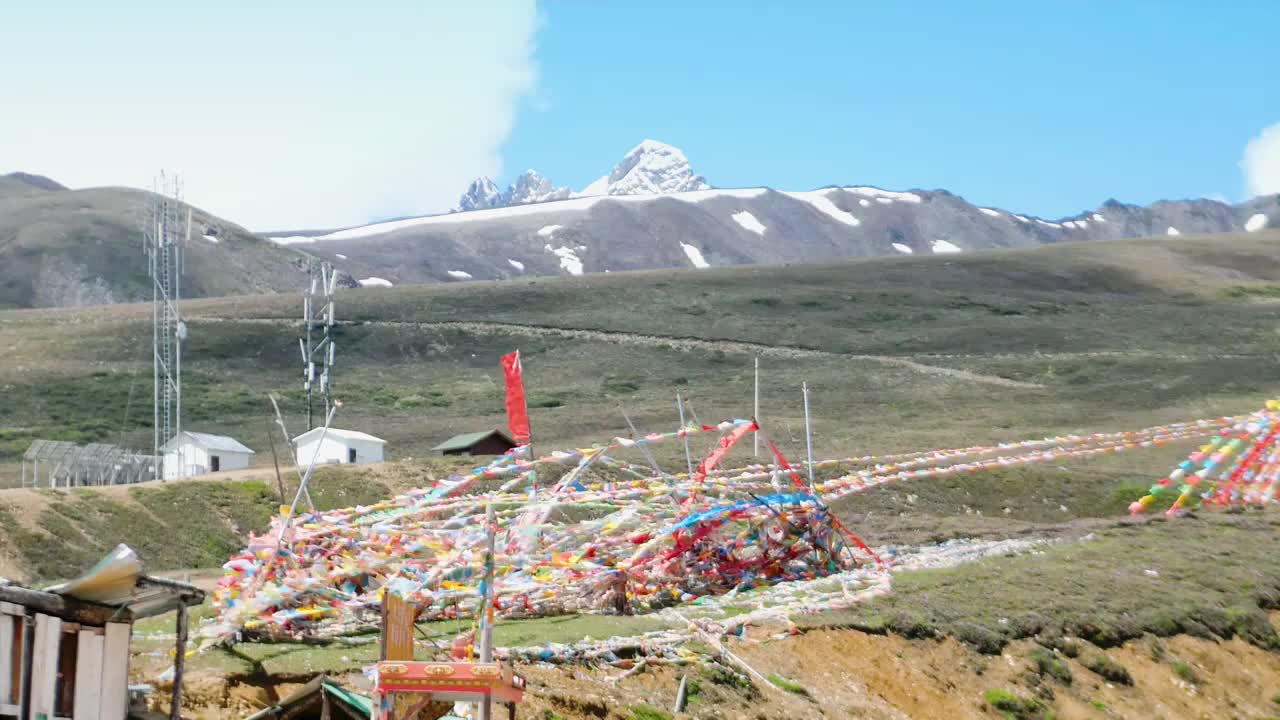 海拔四千米以上大雪山垭口处经幡飘舞藏区藏传佛教五色风马旗是藏族民俗文化象征彩旗飘飘漫天飞舞美好祝愿视频素材