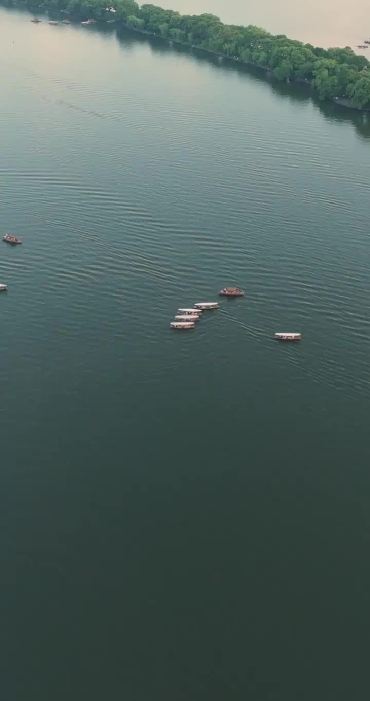 杭州世界文化与自然遗产西子湖畔的湖畔泛舟和高楼林立视频素材