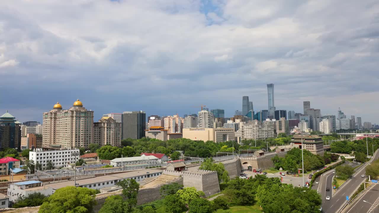 夏天多云天气北京明城墙遗址公园和国贸CBD以及北京站行驶的火车城市风光延时视频素材