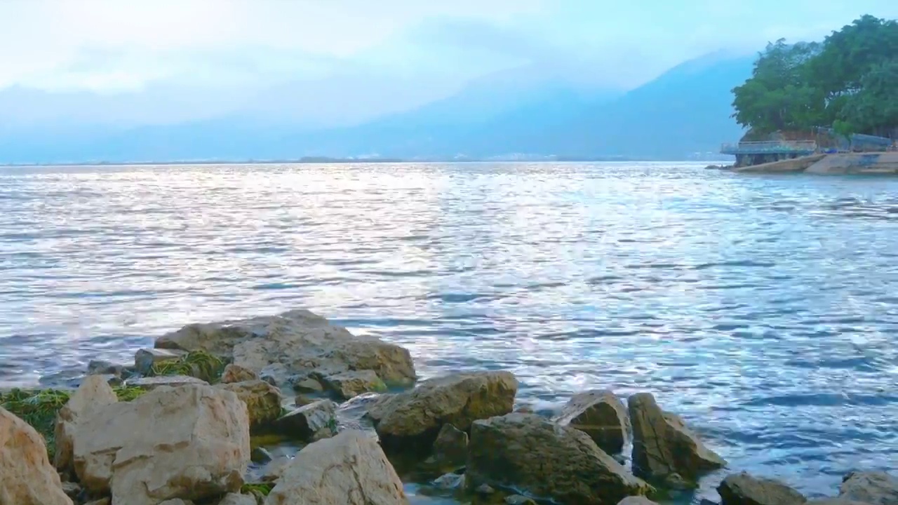 云南大理洱海风景日落岸边礁石海浪轻轻拍打休闲景色人间乐土海天一色空间广阔大气凛然自然地理风景如画美好视频素材