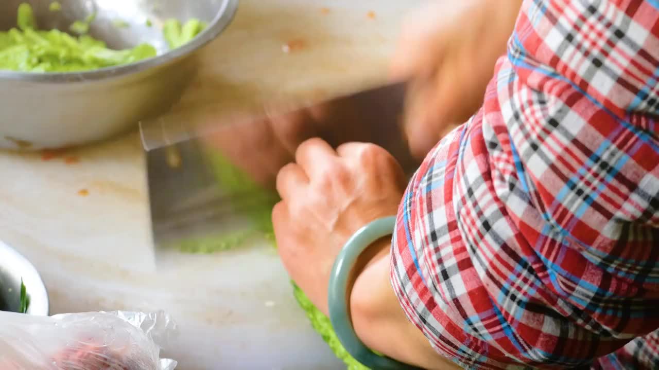 农家小院厨房正在做菜准备晚餐快速把凉瓜切成片状食材农民巧手制作农家饭料理温馨家常菜农家乐餐厅妈妈厨师视频素材