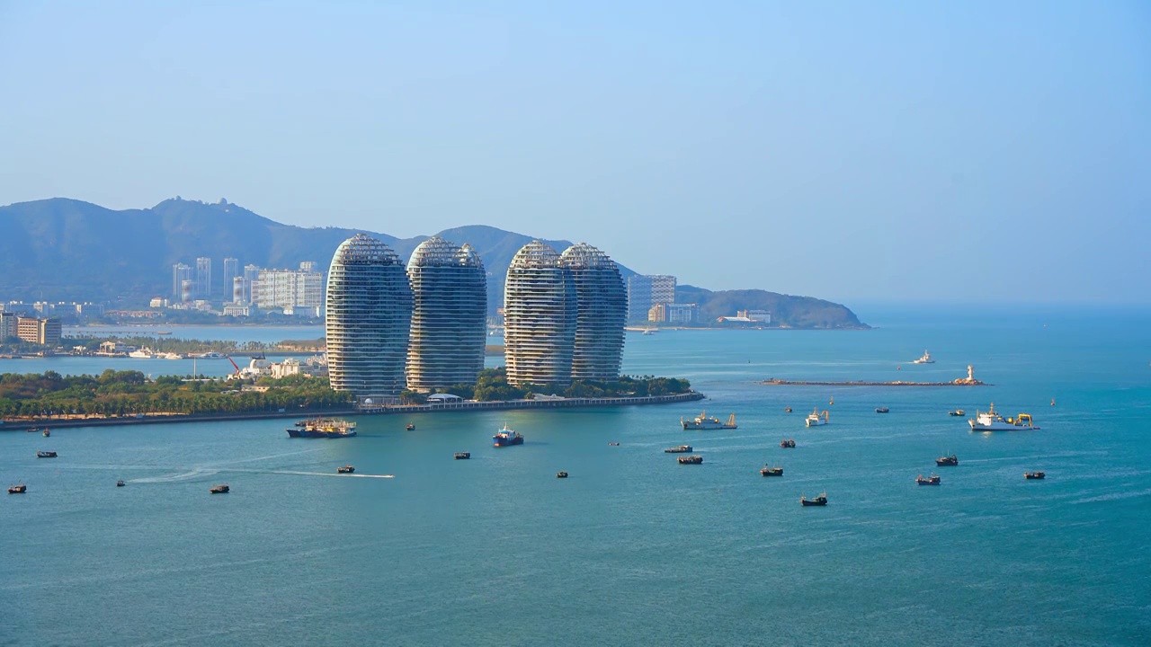 中国海南三亚三亚湾海岸线和凤凰岛城市天际线风光航拍特写视频素材