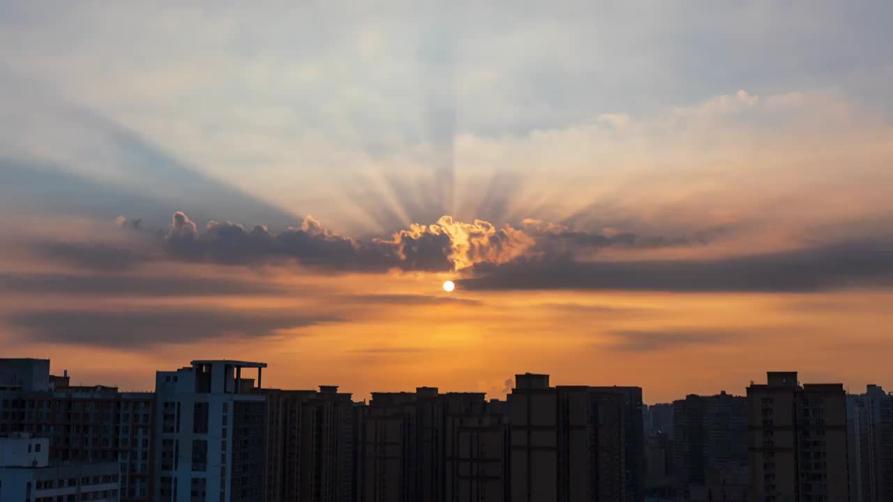 城市天际线日出时分橙红色太阳穿过云层丁达尔放射光延时视频素材