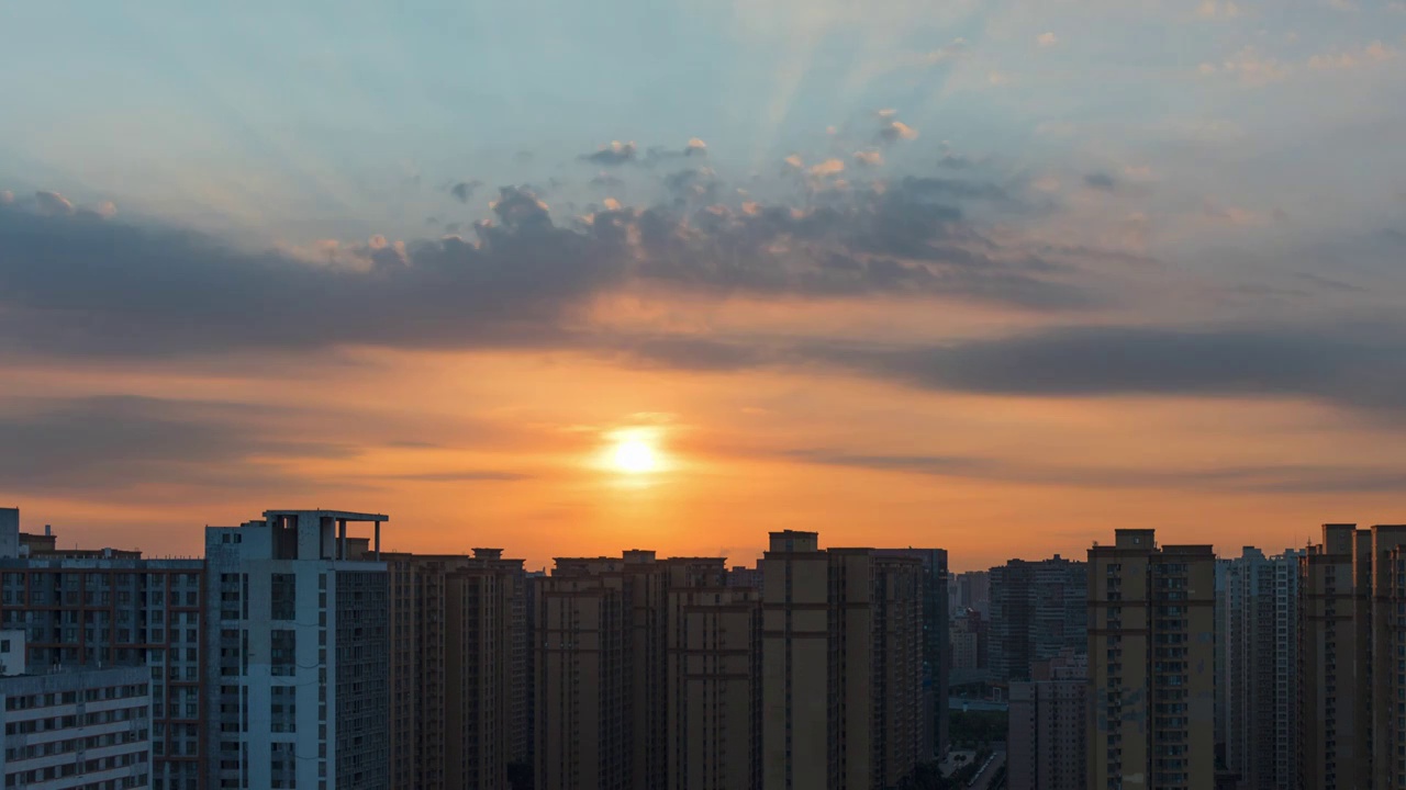 西安城市高楼天际线日出时分橙红色朝霞和太阳穿过云层的丁达尔效应视频素材