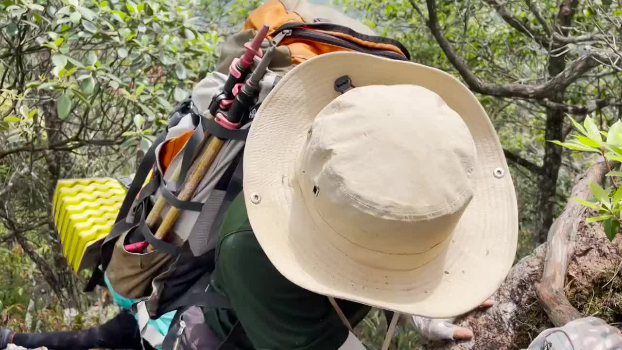 登山者背着巨大登山包翻越石头视频下载