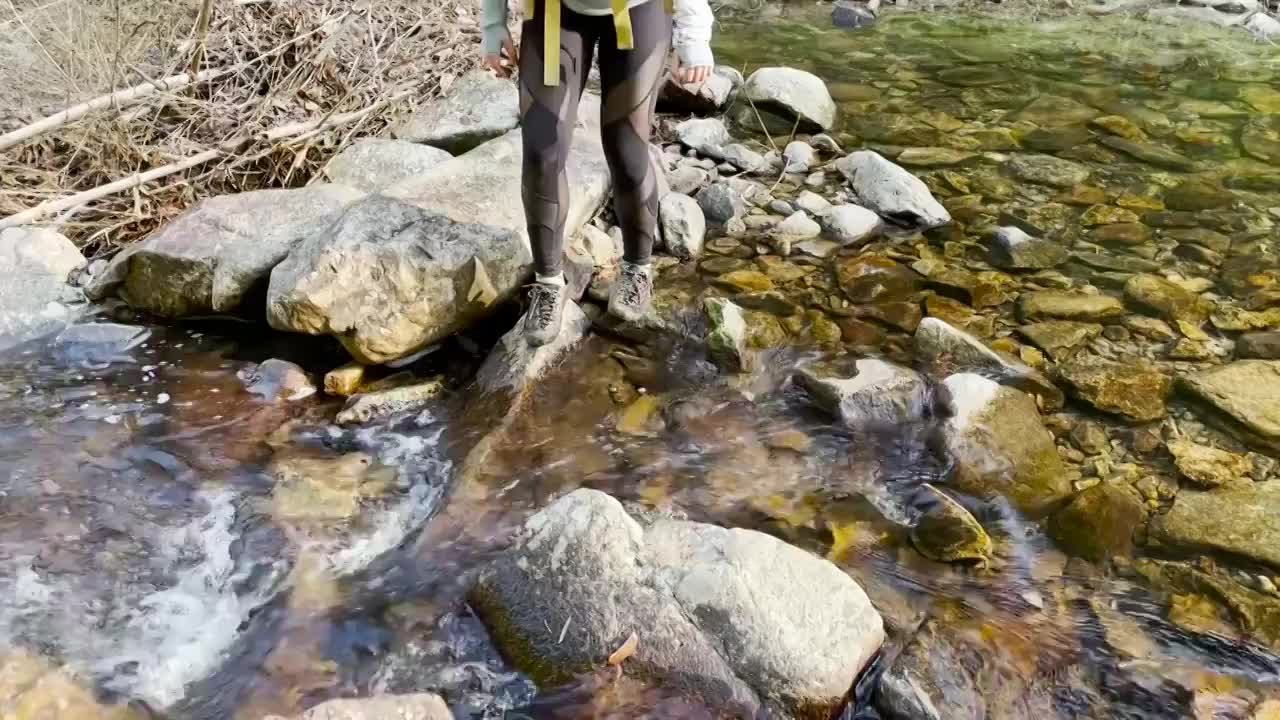 登山者排队依次踩着石头过河视频素材