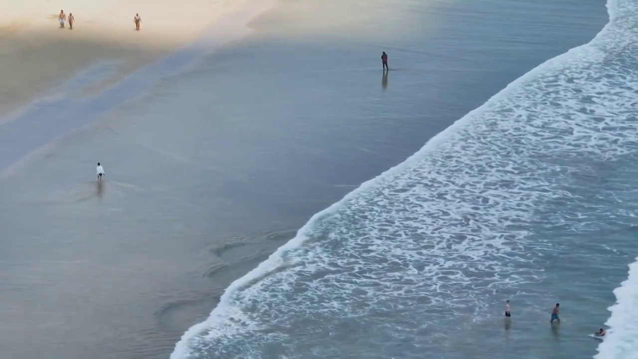 航拍巴厘岛海浪与沙滩上行走的人视频素材