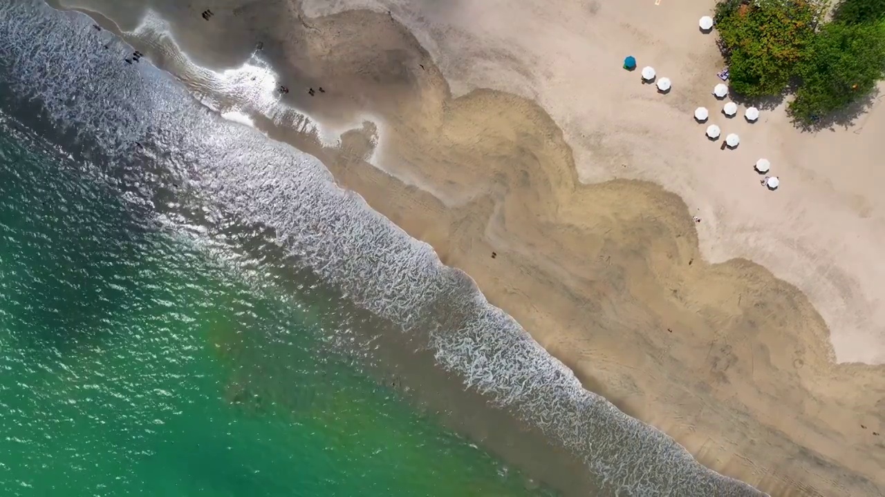 航拍巴厘岛海浪与沙滩上行走的人视频素材