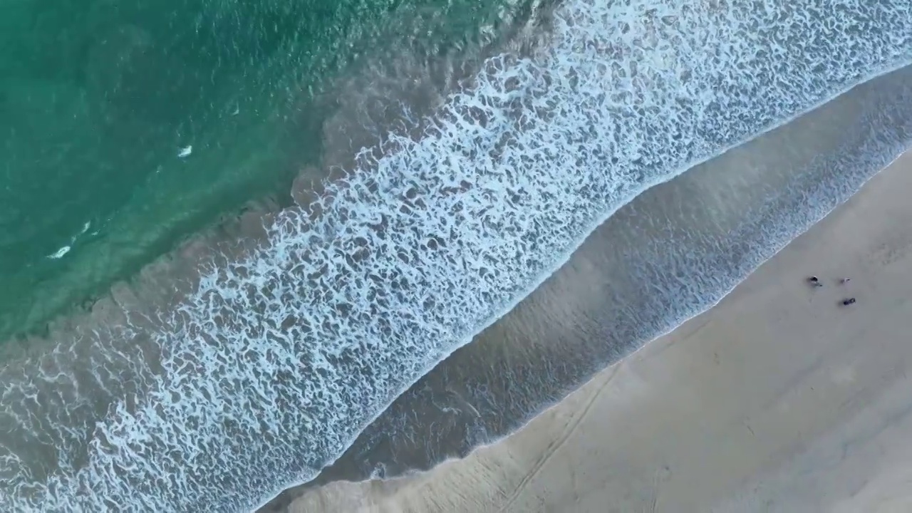 航拍巴厘岛海浪与沙滩上行走的人视频素材