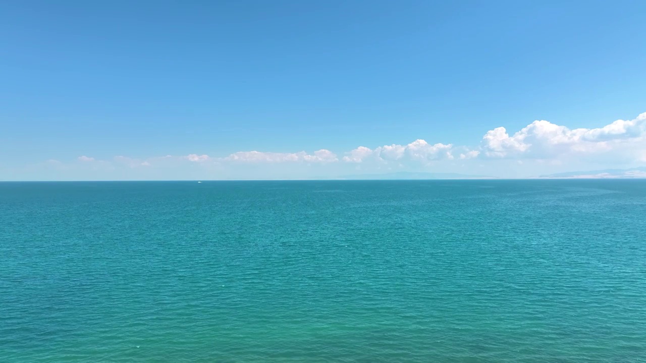 固定机位航拍夏天蓝天白云下的的青海湖湖面湖水（鸟瞰航拍）视频素材