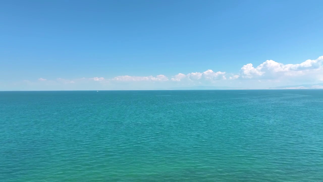 前推镜头航拍夏天蓝天白云下的的青海湖湖水湖面（鸟瞰航拍）视频素材