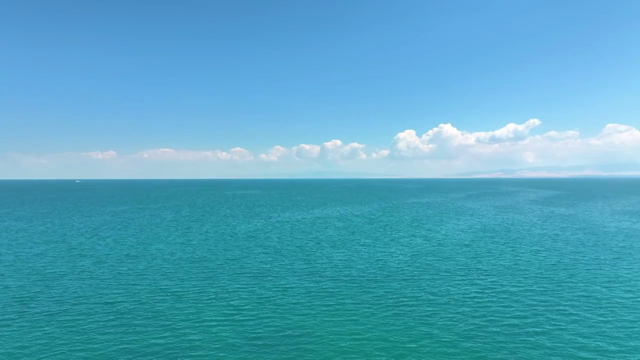 转镜头航拍夏天蓝天白云下的的青海湖湖水湖面（鸟瞰航拍）视频素材