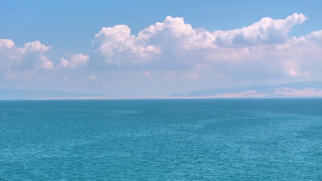 转镜头航拍夏天蓝天白云下的的青海湖湖水湖面（鸟瞰航拍）视频素材