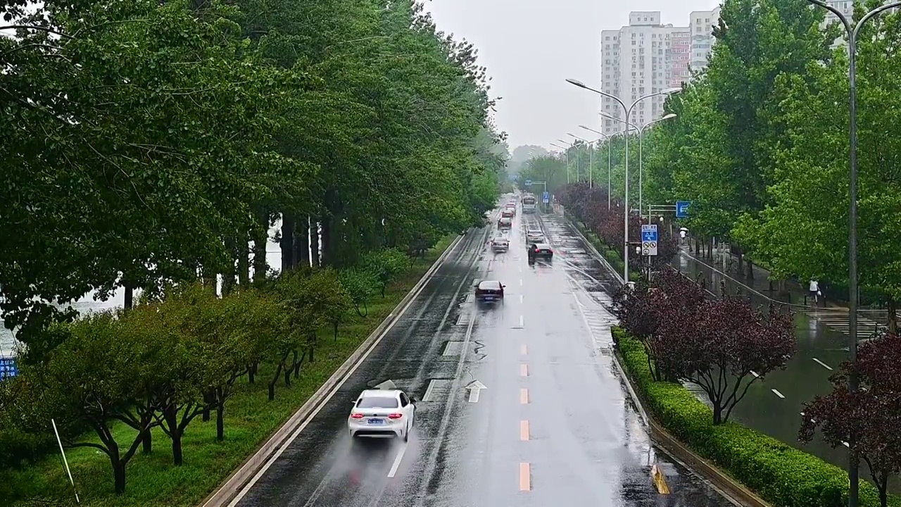 城市里汽车驶过雨水的马路积水路面视频素材