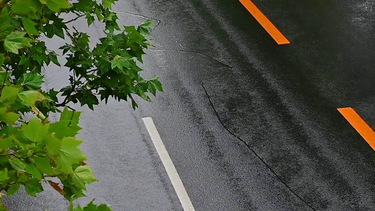 城市里汽车驶过雨水的马路积水路面视频素材