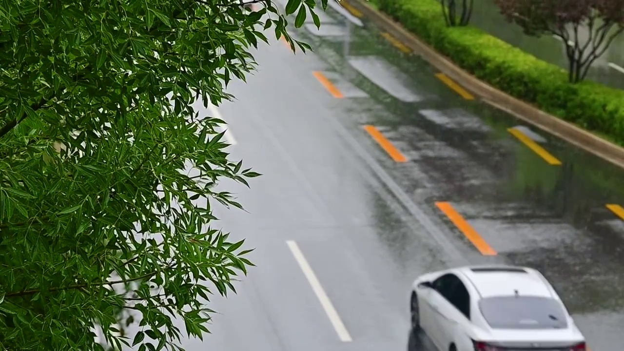 城市里汽车驶过雨水的马路积水路面视频素材