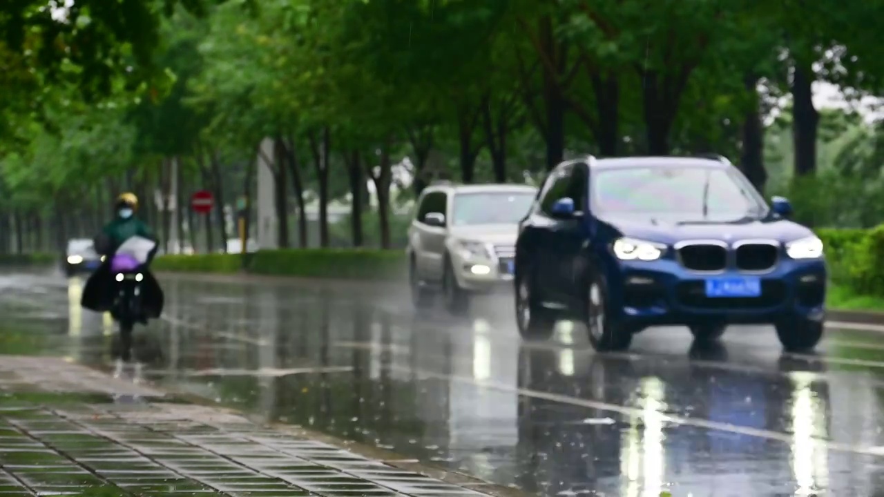 城市里汽车驶过雨水的马路积水路面视频素材