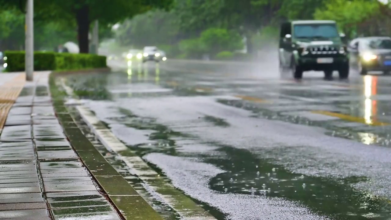 城市里汽车驶过雨水的马路积水路面视频素材