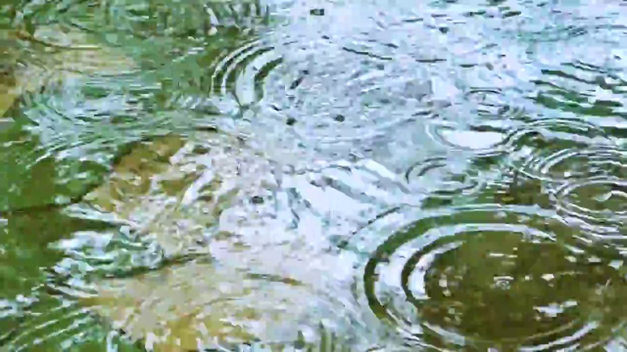 雨水滴落在水面上溅起的水花圆圈水泡视频素材