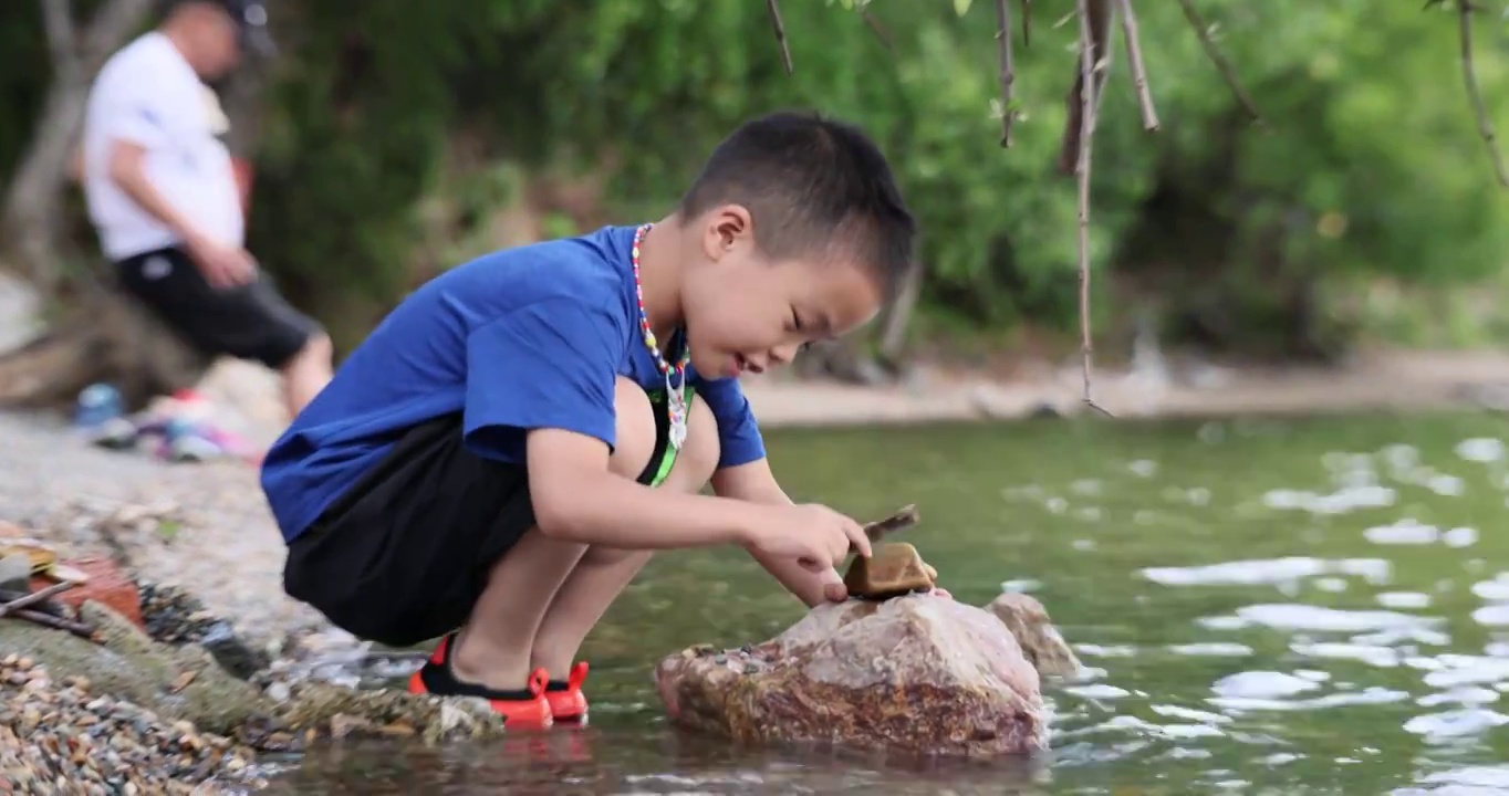 人像旅游：小男孩在泸沽湖女神湾景区游玩戏水视频素材