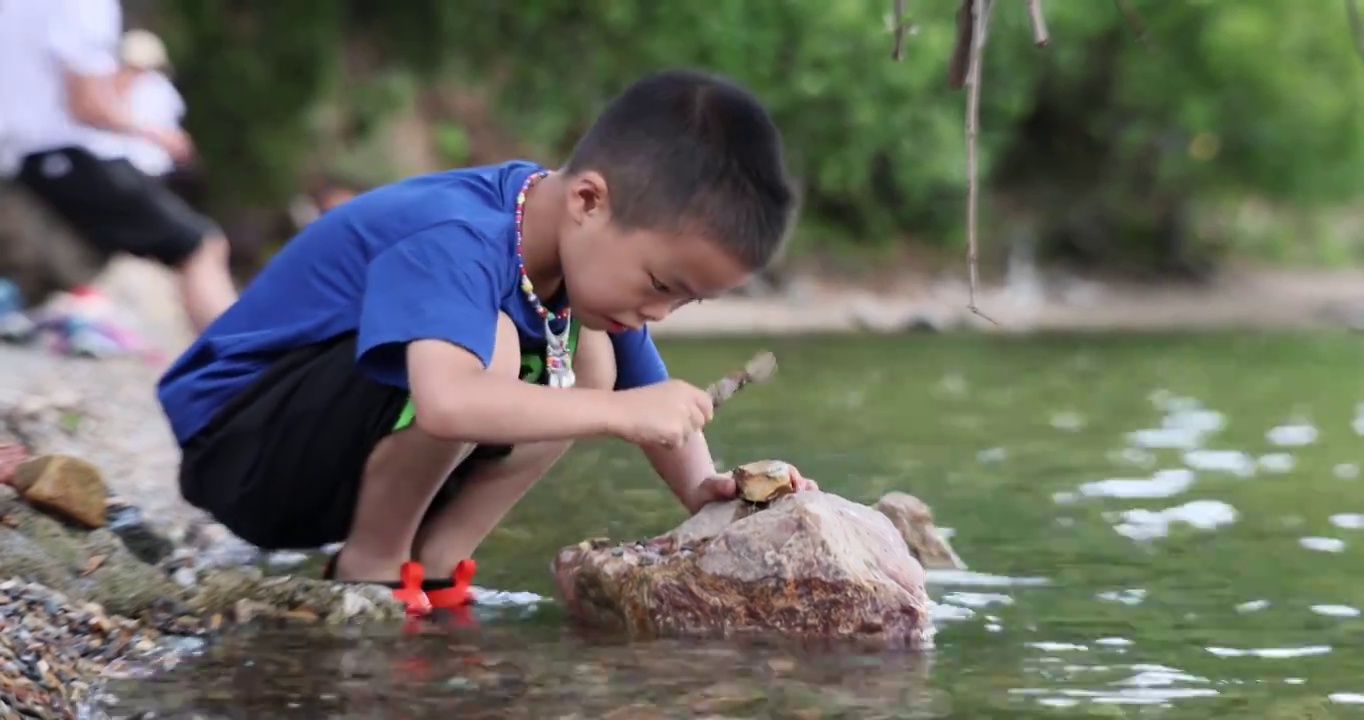 人像旅游：小男孩在泸沽湖女神湾景区游玩戏水视频素材