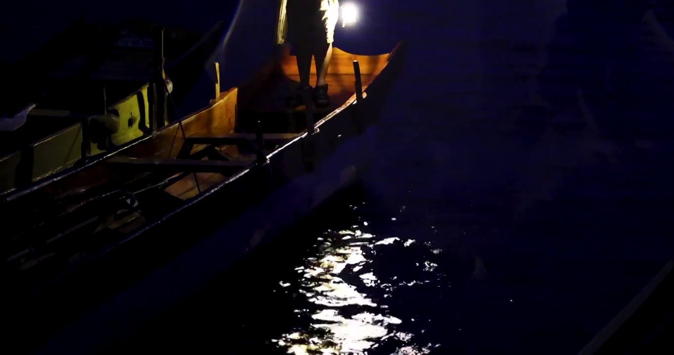 旅游景区：泸沽湖的雨夜，船夫提灯站在船头视频素材